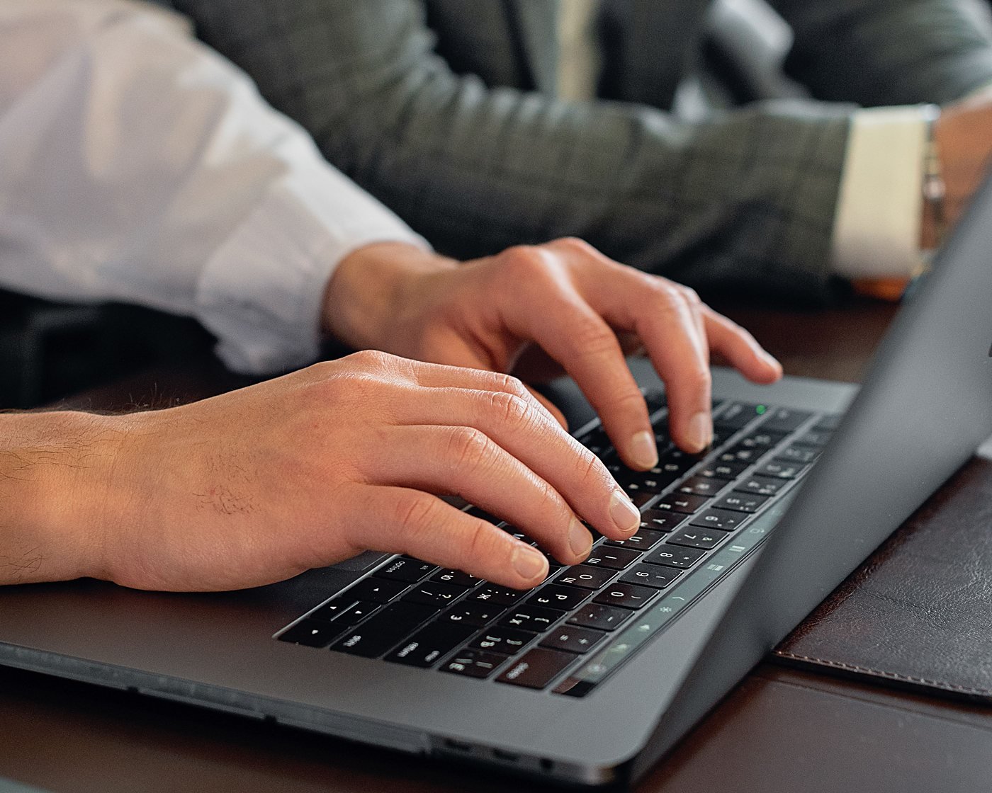 Hands typing on a laptop during a working session