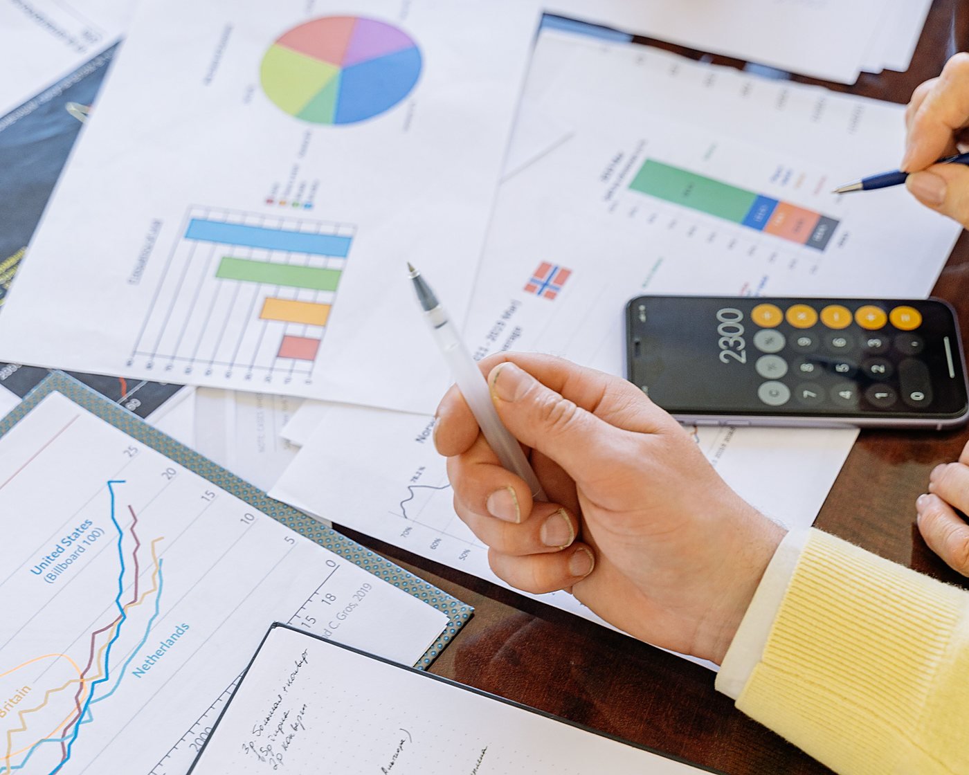 Charts and market data being reviewed on paper and laptop